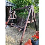 A LARGE WOODEN GARDEN SWING BENCH.