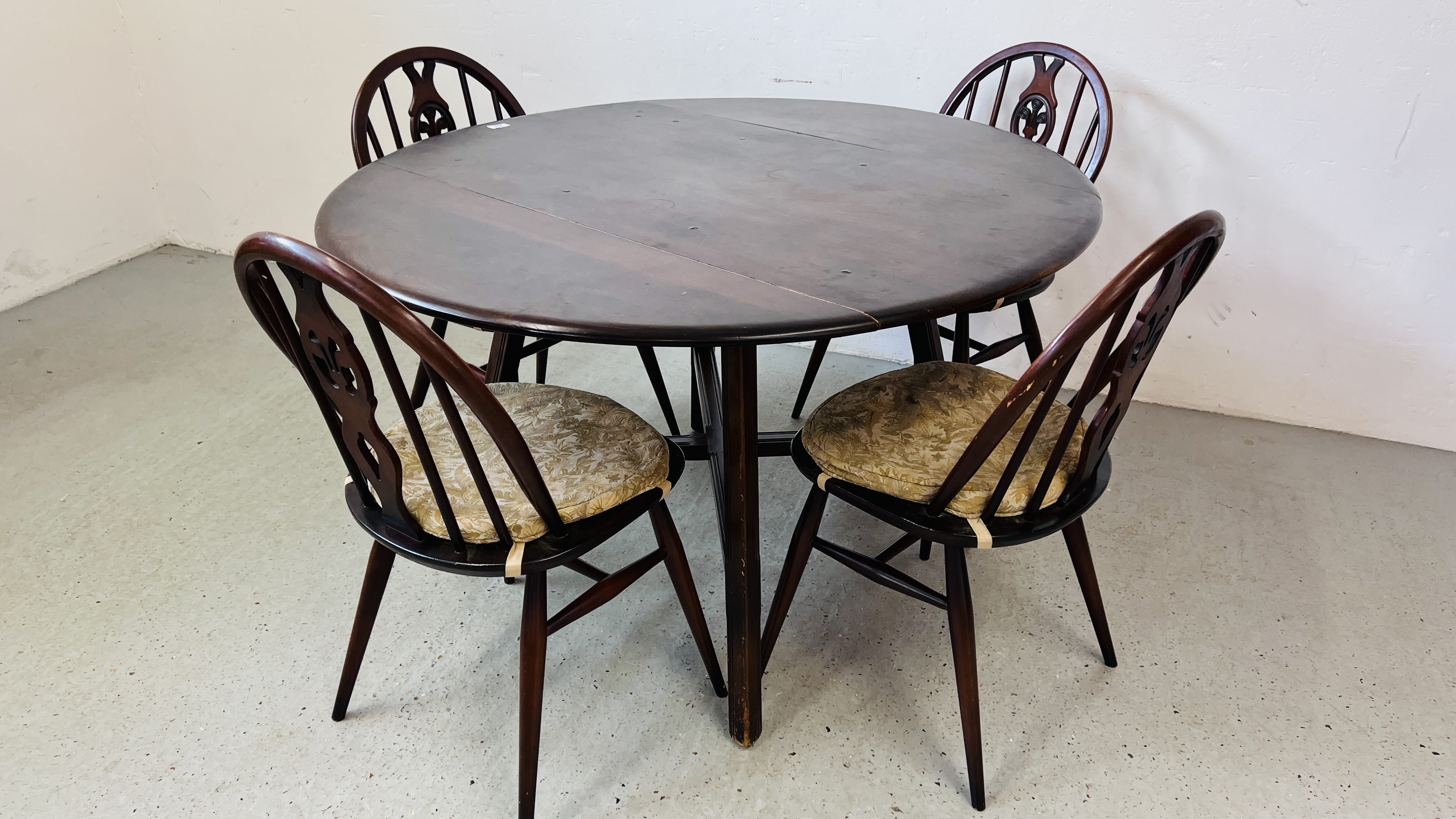 AN ERCOL DROP SIDE DINING TABLE WITH CROSS STRETCHER SUPPORT AND FOUR ERCOL DINING CHAIRS 104CM X