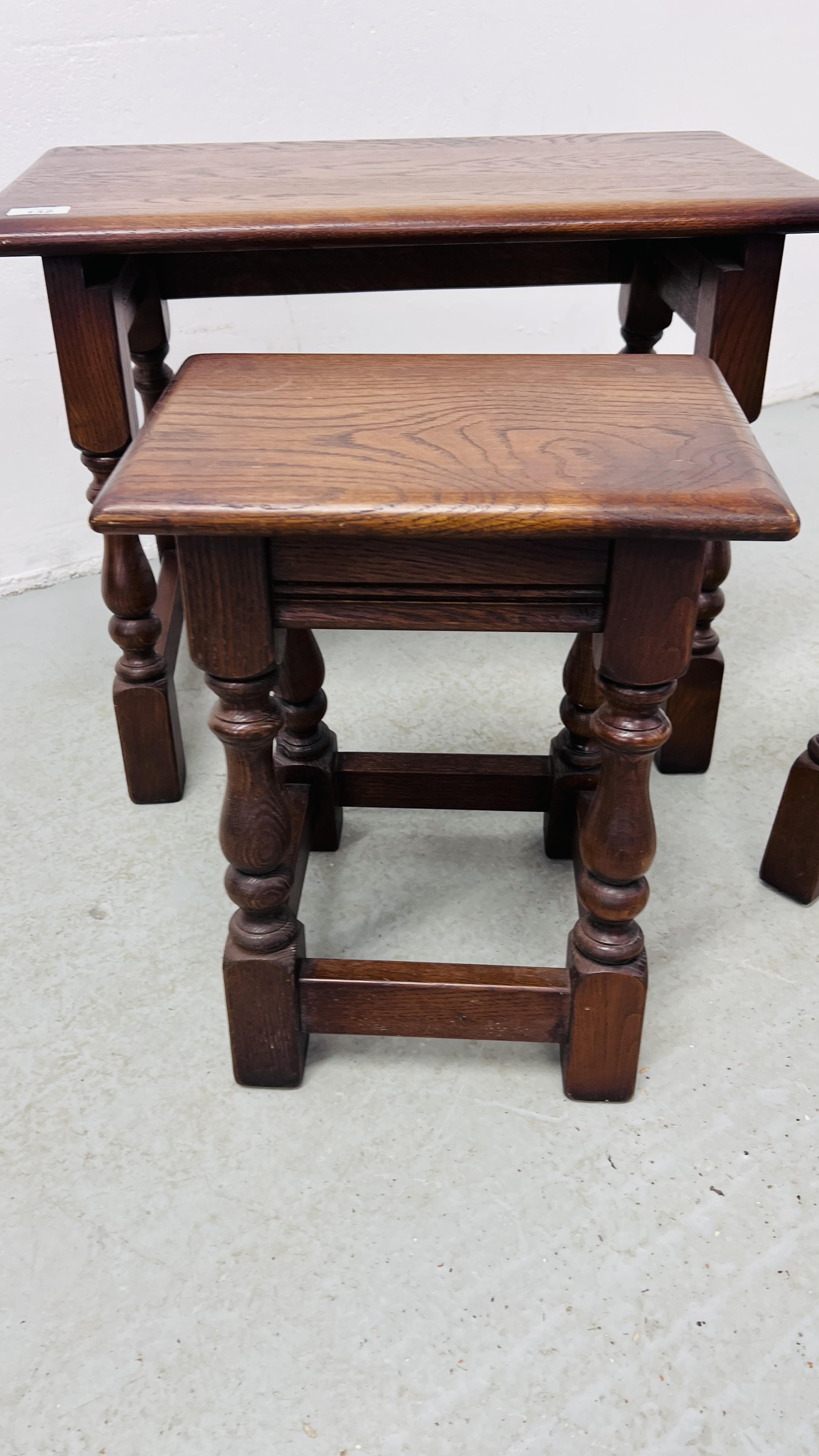 A NEST OF THREE REPRODUCTION GOOD QUALITY OAK TABLES (THE LARGEST 60CM. X 32CM. - Image 3 of 8