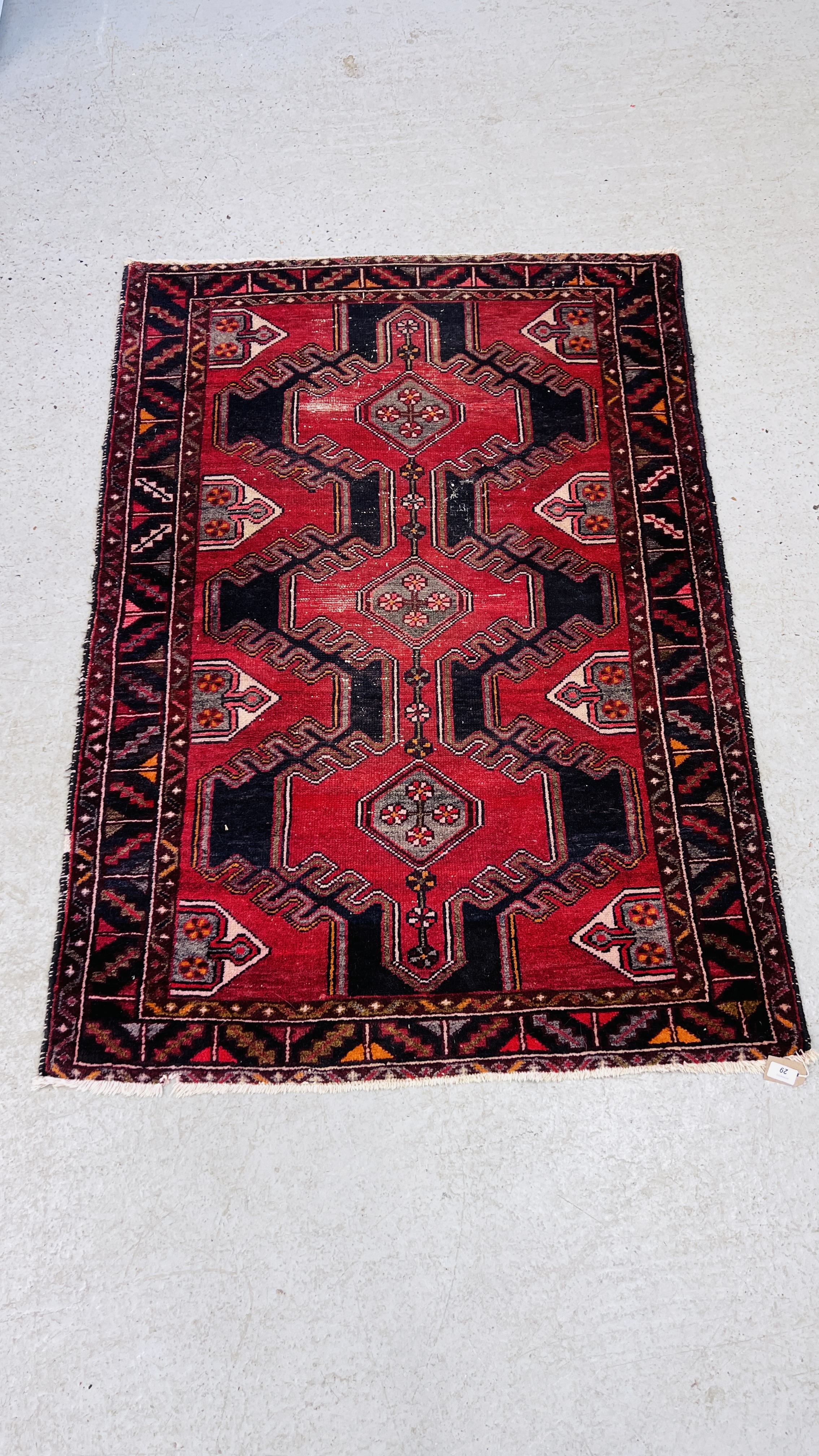 A PERSIAN RUG THE CONJOINED MOTIFS ON A NAVY BLUE FIELD,