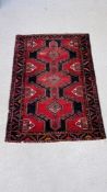 A PERSIAN RUG THE CONJOINED MOTIFS ON A NAVY BLUE FIELD,