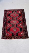 A PERSIAN RUG THE CONJOINED MOTIFS ON A NAVY BLUE FIELD,