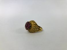 AN IMPRESSIVE DESIGNER YELLOW METAL (INDISTINCT MARKS) RUBY CLUSTER RING OF RAISED DESIGN.