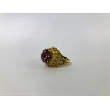 AN IMPRESSIVE DESIGNER YELLOW METAL (INDISTINCT MARKS) RUBY CLUSTER RING OF RAISED DESIGN.