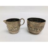 AN UNUSUAL SILVER SUGAR BOWL AND CREAM JUG EMBOSSED DECORATION DEPICTING ANIMALS,