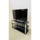 A PANASONIC 40 INCH LED TELEVISION ON THREE TIER GLASS STAND COMPLETE WITH REMOTE - SOLD AS SEEN.