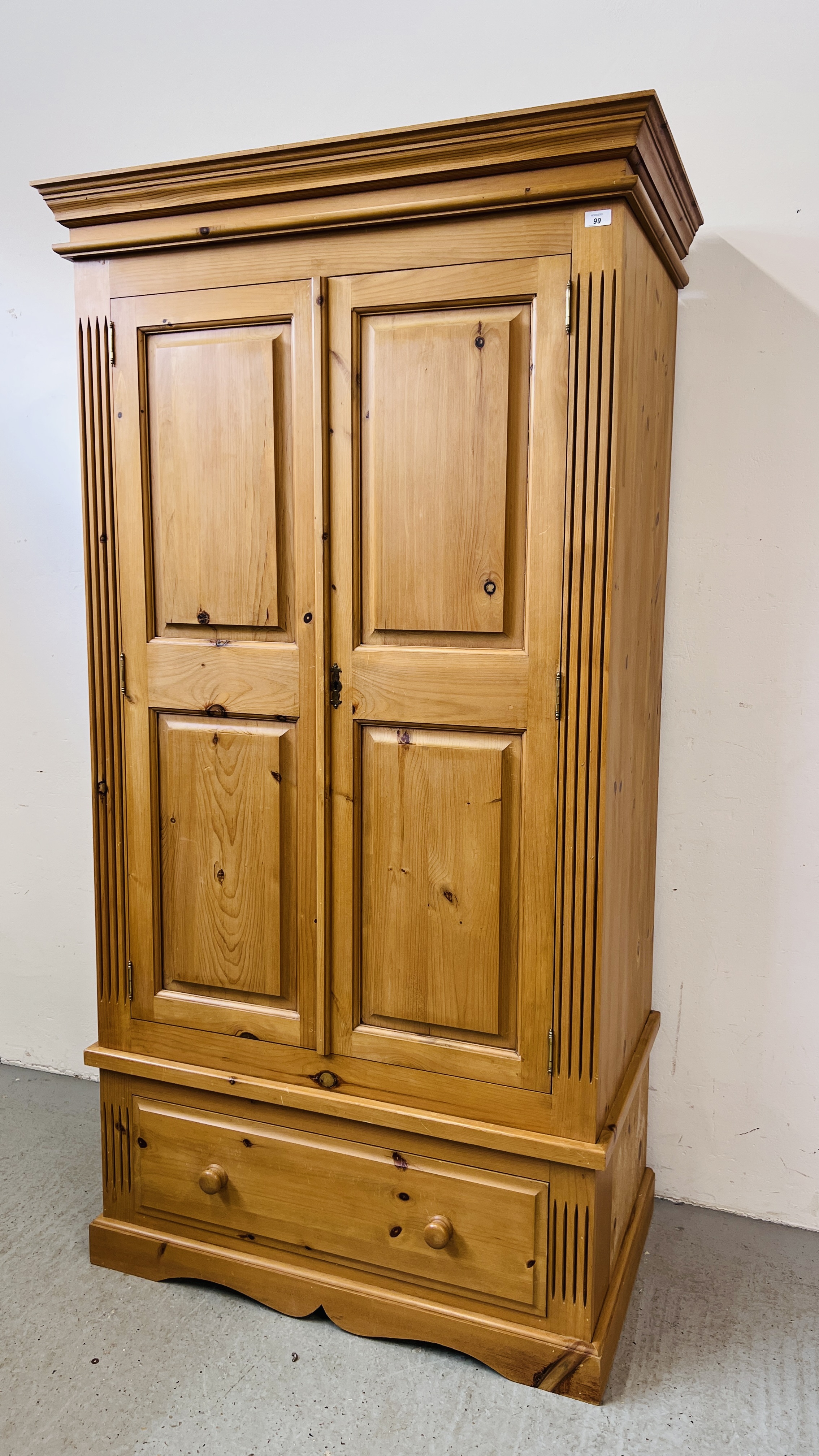 A GOOD QUALITY SOLID PINE TWO DOOR WARDROBE ON SINGLE DRAWER BASE W 102CM X D 60CM X H 194CM.