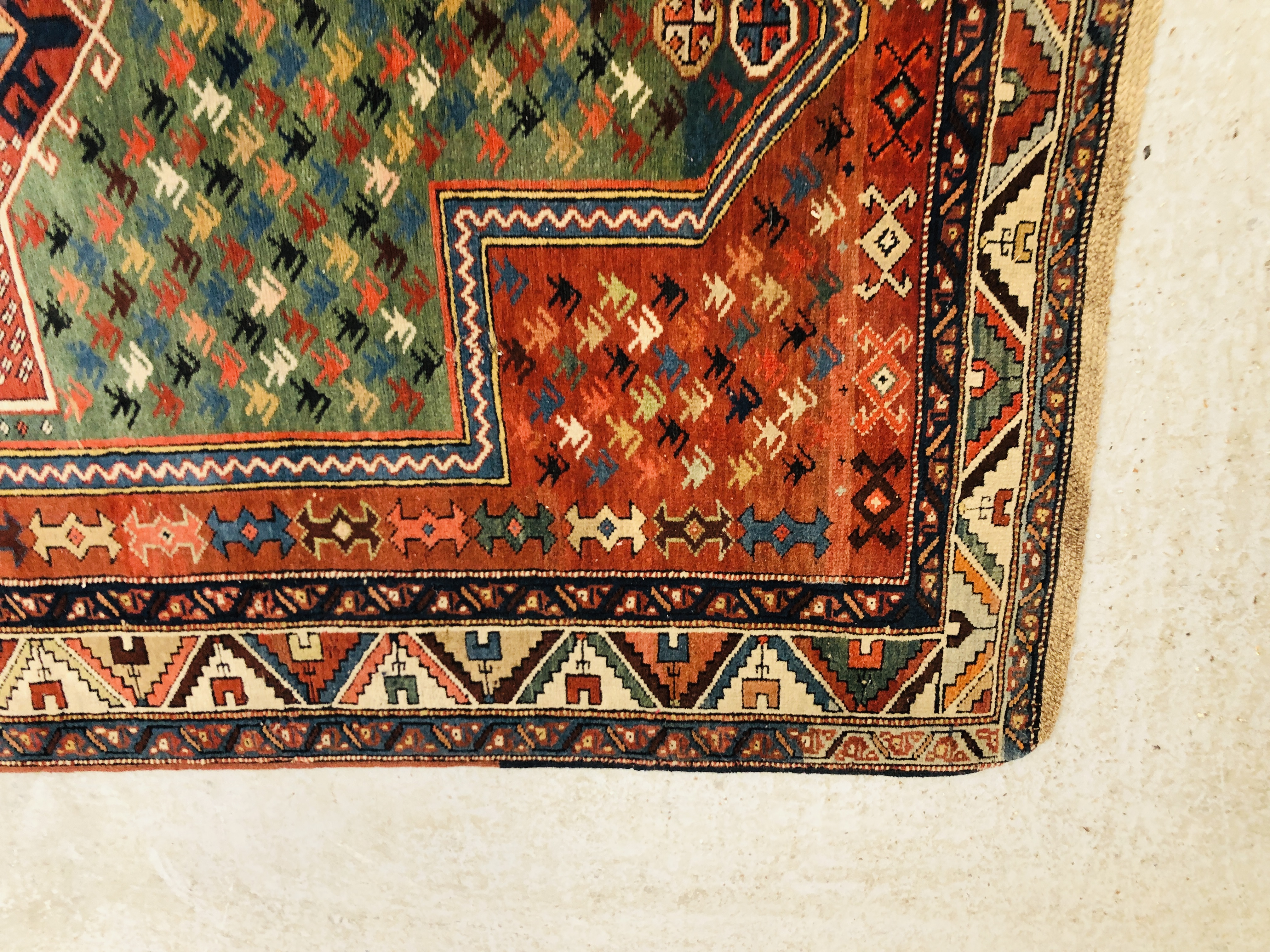 A CAUCASIAN PRAYER RUG THE MIHRAB HAVING A GREEN FIELD FILLED WITH HOOKED MOTIFS AROUND A SECONDARY - Image 3 of 6