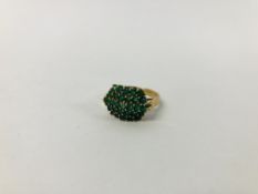 A 9CT. GOLD EMERALD CLUSTER RING.