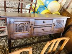 A REPRODUCTION OAK SIDEBOARD STANDING ON TURNED LEGS,