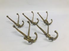 FIVE ANTIQUE BRASS COAT HOOKS SOME STAMPED "BR" ETC.