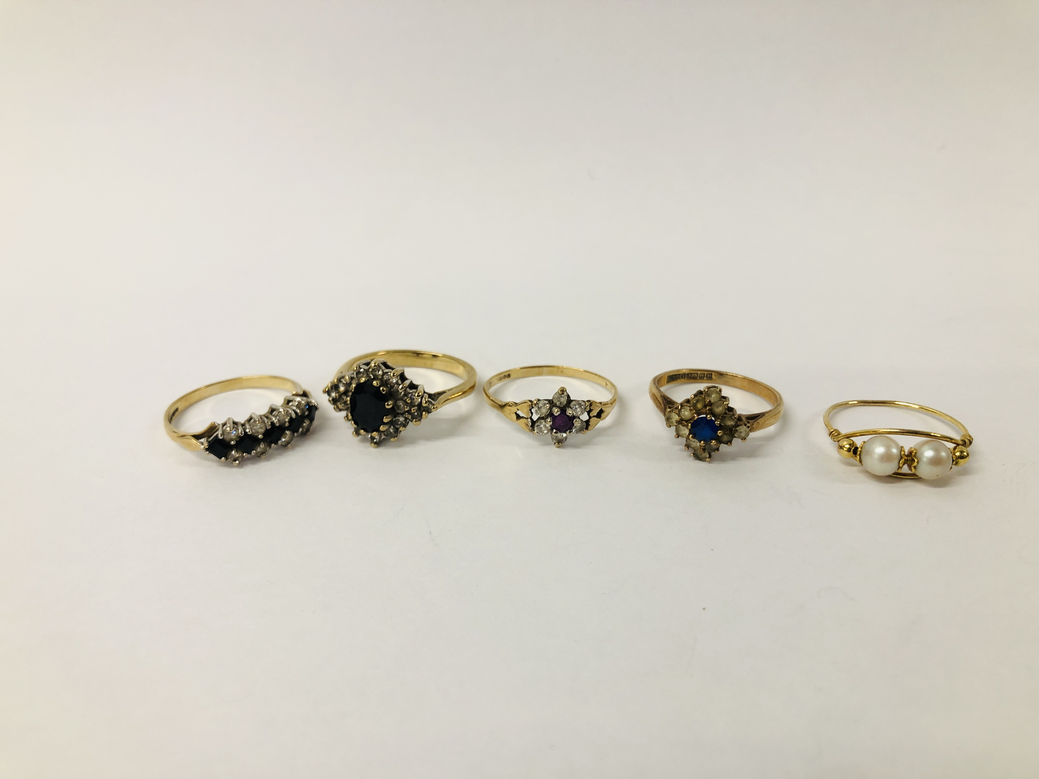 FOUR VARIOUS 9CT. GOLD STONE SET DRESS RINGS AND ONE PEARL SET RING MARKED 9KT.