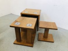 A SET OF THREE OAK GRADUATING TABLES COMPLETE WITH BUILT IN COASTERS, LARGEST 50CM X 50CM X 50CM.