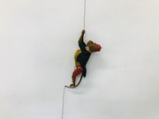 A VINTAGE TINPLATE CIRCUS MONKEY WITH CLIMBING ACTION ON PULL CORD.