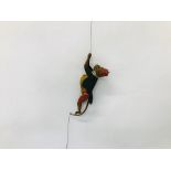 A VINTAGE TINPLATE CIRCUS MONKEY WITH CLIMBING ACTION ON PULL CORD.