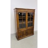 A GOOD QUALITY REPRODUCTION OAK TWO DOOR GLAZED DISPLAY CABINET ON TWO DOOR CUPBOARD BASE W 97CM,