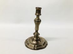 A CONTINENTAL CAST SILVER CANDLESTICK, THE GADROONED COLUMN ON A STEPPED AND SCROLLED BASE - 21.