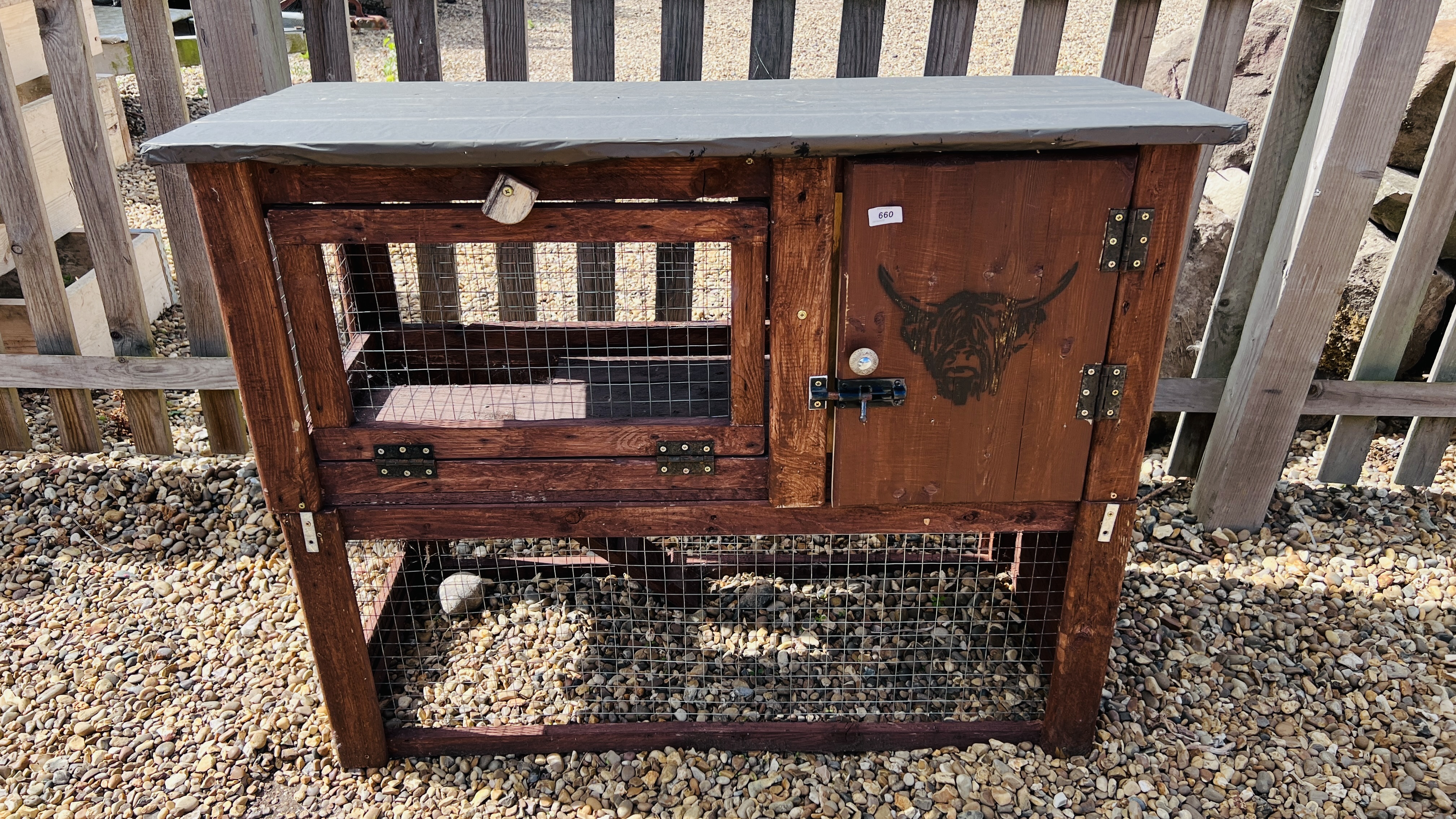 A HANDMADE TWO TIER ANIMAL HUTCH WITH BULL FACE STENCIL.
