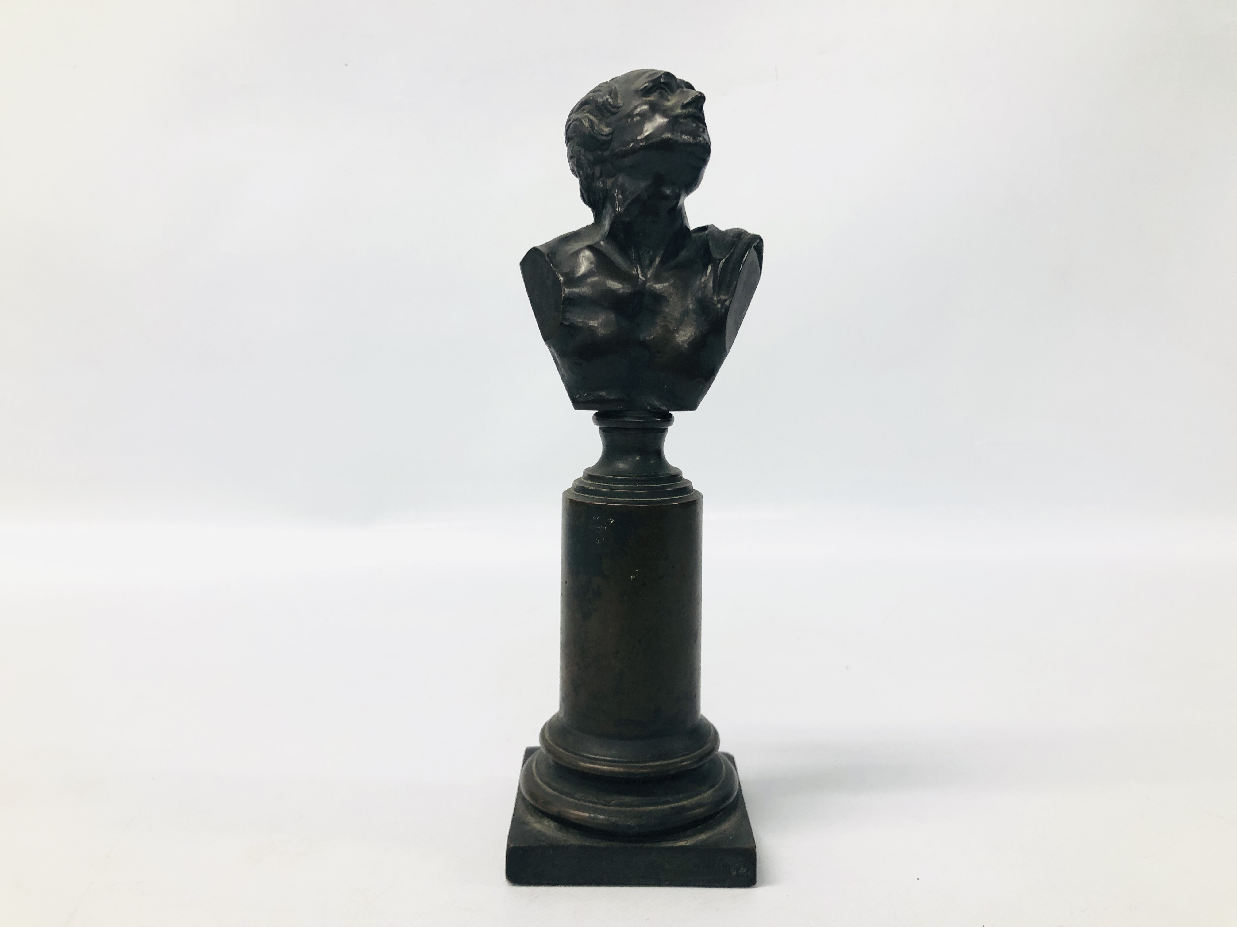 A BRONZE BUST OF A GENTLEMAN MOUNTED ON A COLUMN WITH SQUARE BASE, H 25CM.