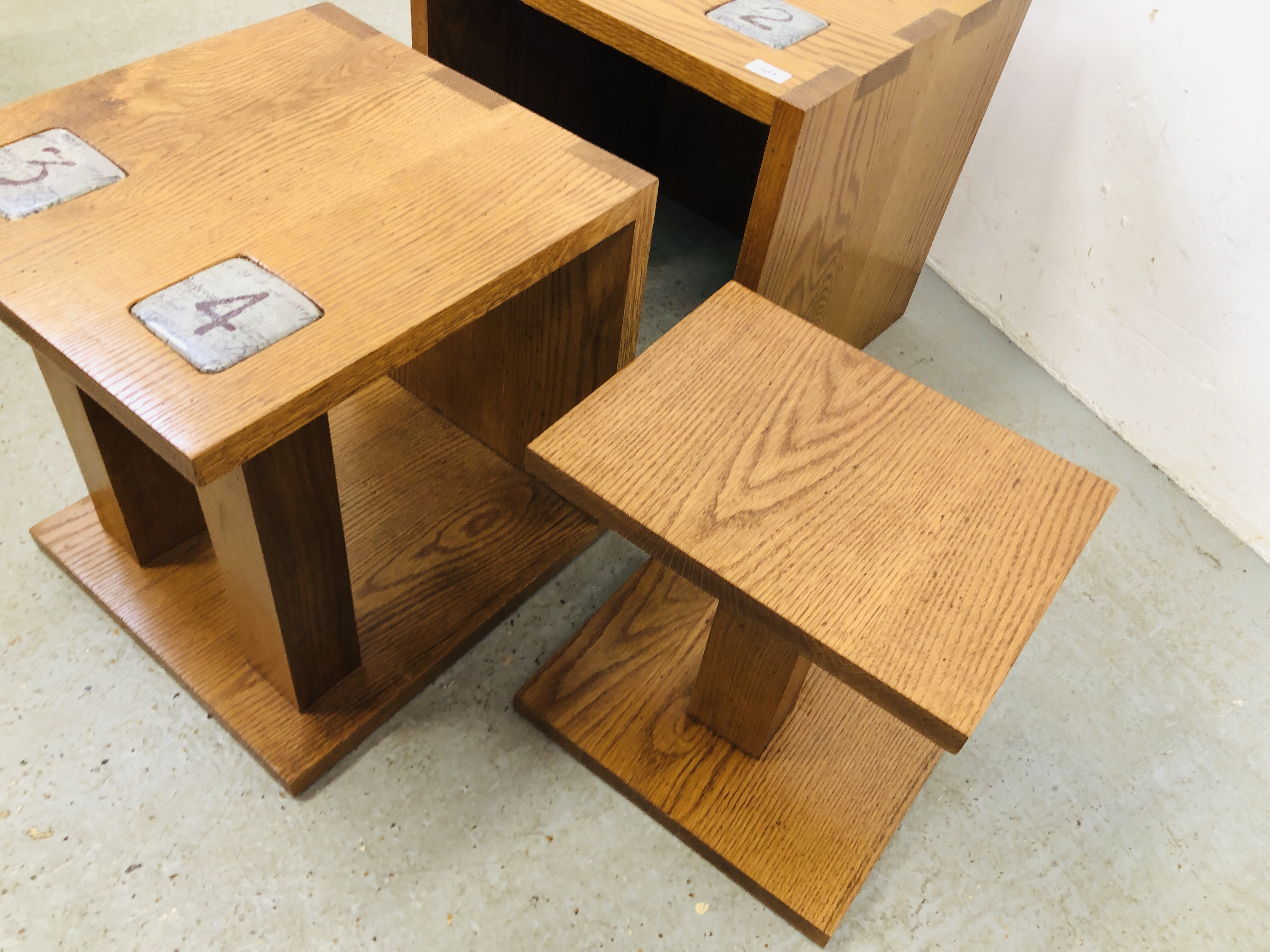 A SET OF THREE OAK GRADUATING TABLES COMPLETE WITH BUILT IN COASTERS, LARGEST 50CM X 50CM X 50CM. - Image 3 of 5