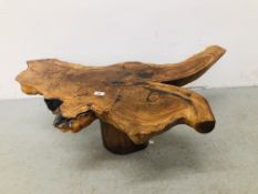 A STAINED WOOD SLAB COFFEE TABLE STANDING ON SINGLE PEDESTAL LOG W 102CM, D 54CM, H 33CM.