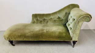 A VICTORIAN CHAISE LOUNGE UPHOLSTERED IN GREEN VELOUR.