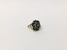 A 9CT. GOLD DIAMOND AND SAPPHIRE RING, SETTING OF FLOWER HEAD DESIGN.