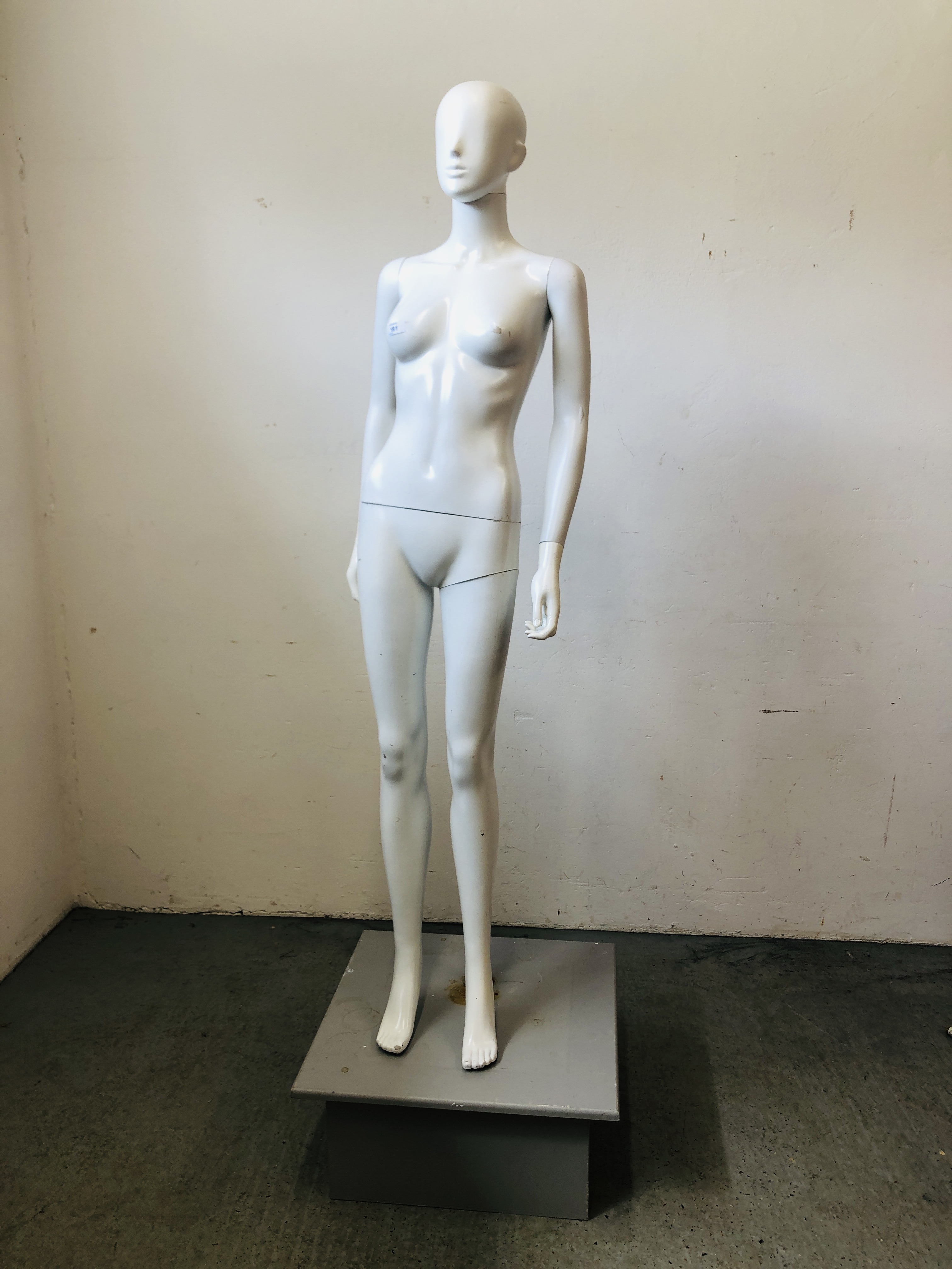 A FULL SIZE FEMALE MANNEQUIN ON SQUARE BASE.