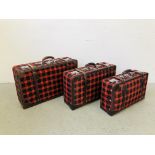 A SET OF THREE GOLDEN LEAF BLACK AND RED PATTERNED LEATHER BOUND SUIT CASES WITH KEYS.