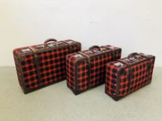 A SET OF THREE GOLDEN LEAF BLACK AND RED PATTERNED LEATHER BOUND SUIT CASES WITH KEYS.