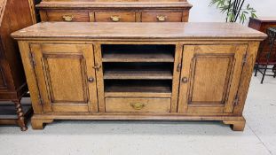 A BESPOKE SOLID OAK DRESSER BASE THE CENTRAL SHELVED SECTION FLANKED BY CABINET DOORS WIDTH 165CM.