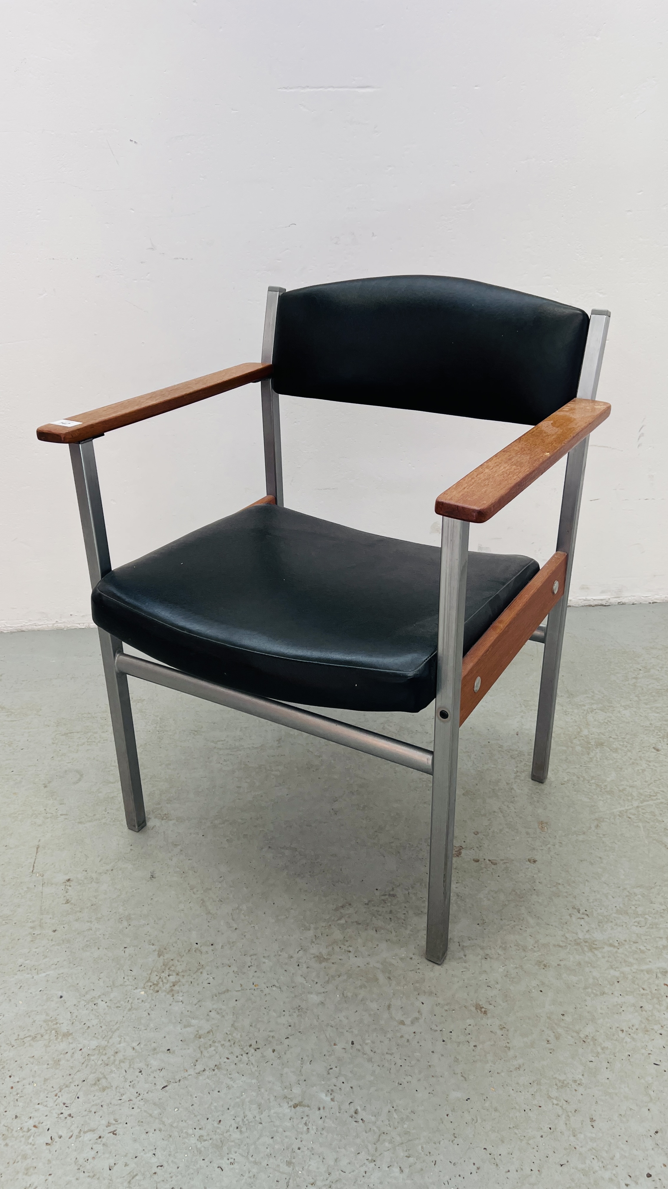 A MID CENTURY METAL FRAMED ELBOW CHAIR.