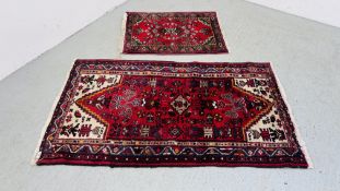 A RED PATTERNED HAMADAN RUG 88CM X 62CM AND A LARGER RED PATTERNED HAMADAN RUG 1.55M X .90M.