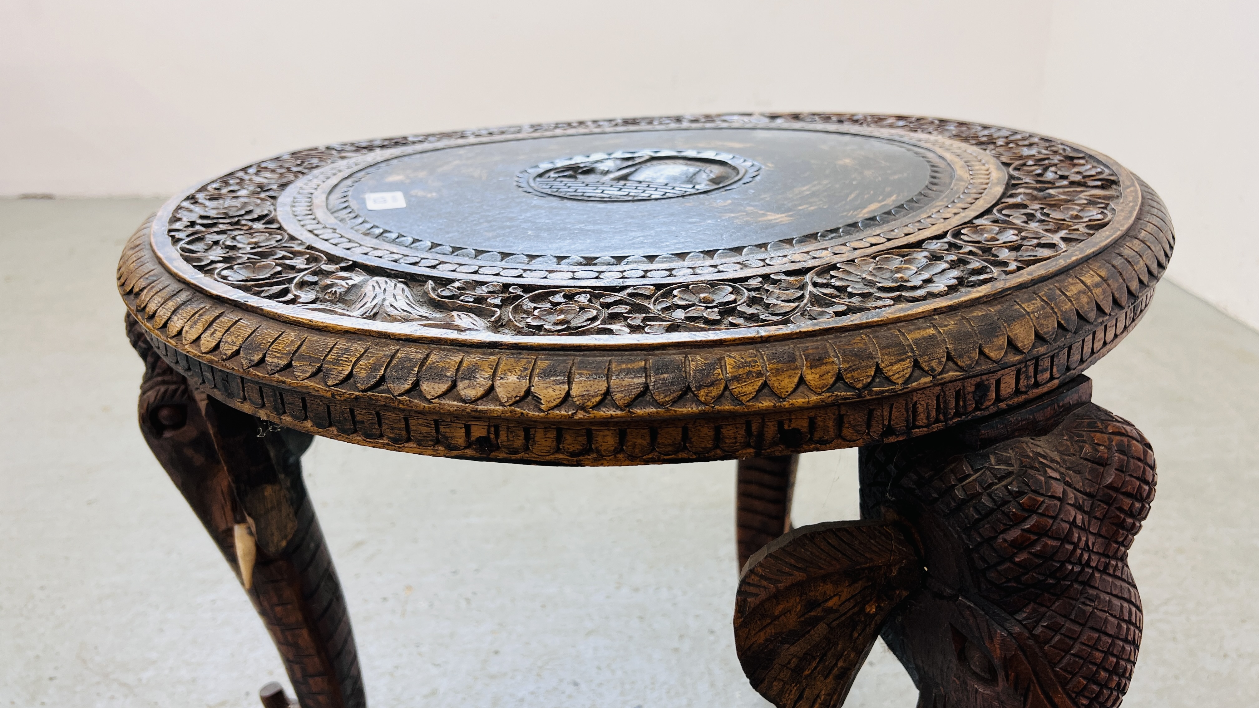 A HARDWOOD CARVED EASTERN CIRCULAR TABLE WITH ELEPHANT HEAD DETAILING TO LEGS. - Image 7 of 8