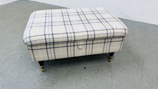 A MODERN OATMEAL UPHOLSTERED HINGE TOP FOOTSTOOL WITH CHECK PATTERN STANDING ON BRASS CASTERS 95 X