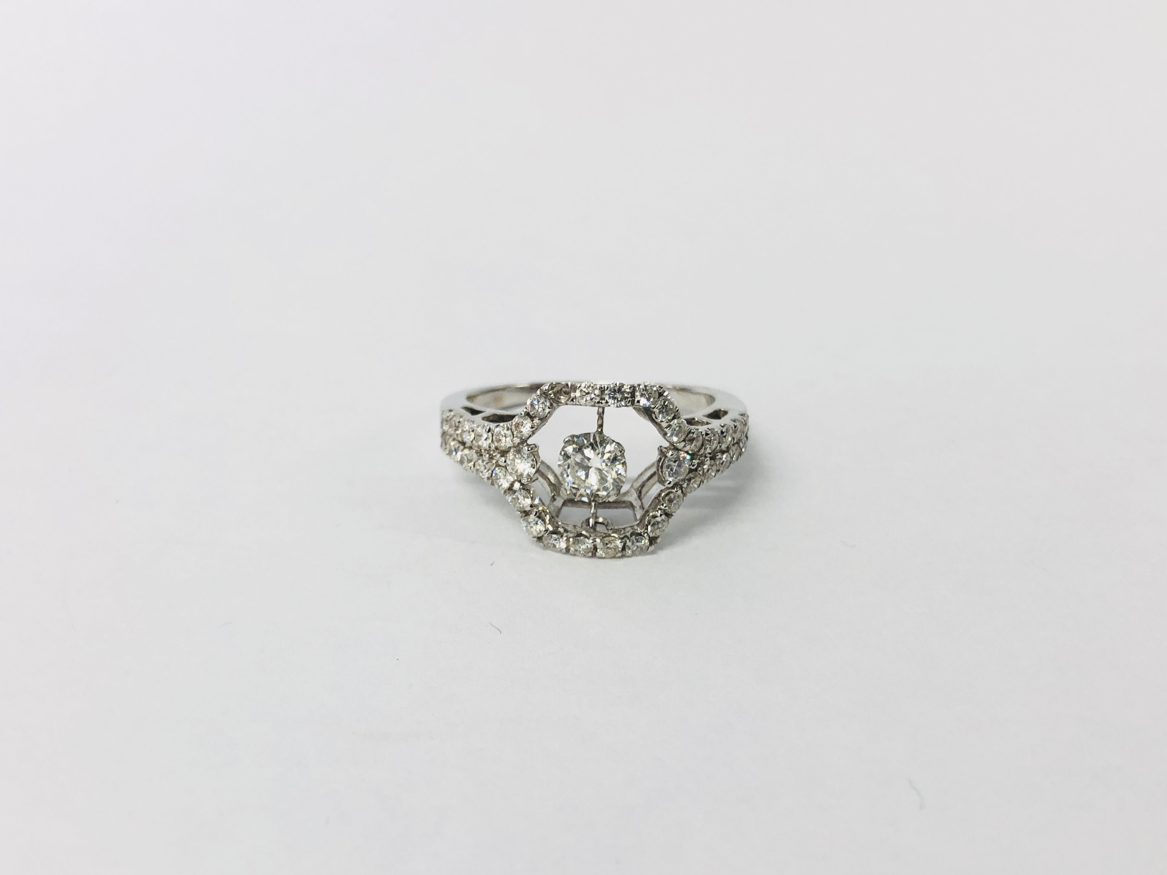 A MODERN CONTEMPORARY DIAMOND SET RING, NO HALLMARK, THE CENTRAL PIVOTING DIAMOND APPROX .