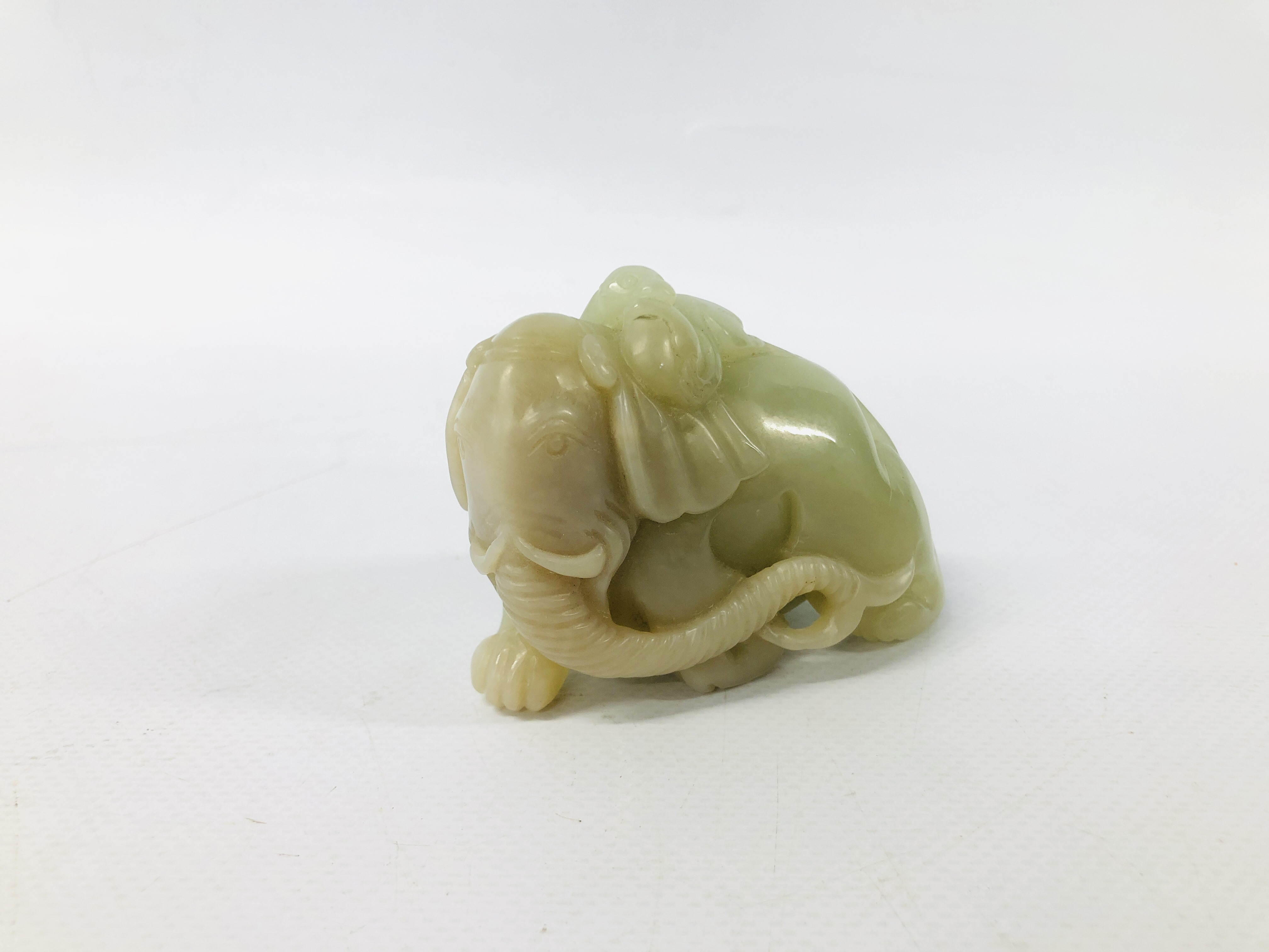 WELL CARVED CHINESE PALE CELADON JADE OF A MONKEY HOLDING A PEACH UPON THE BACK OF AN ELEPHANT,