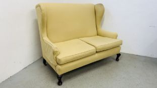 AN EARLY C20TH WINGED TWO SEATER SOFA ON A SQUAT CABRIOLE FEET WIDTH 139CM. HEIGHT 110CM.