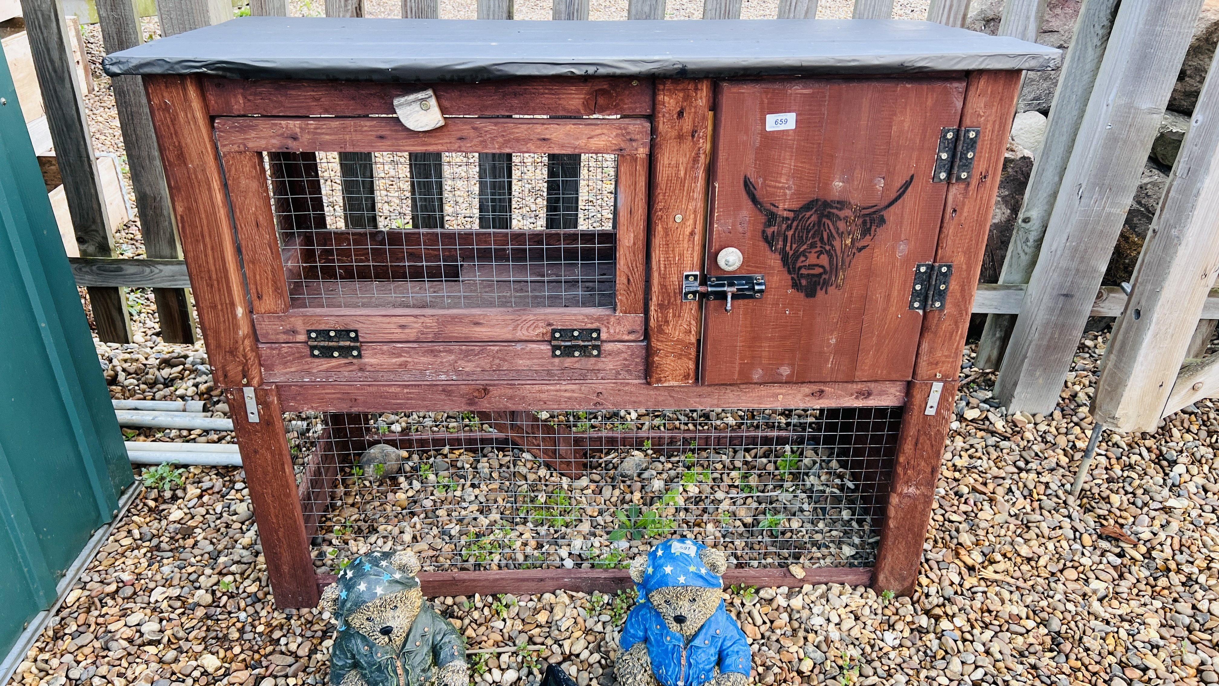 A HANDMADE TWO TIER ANIMAL HUTCH WITH BULL FACE STENCIL.