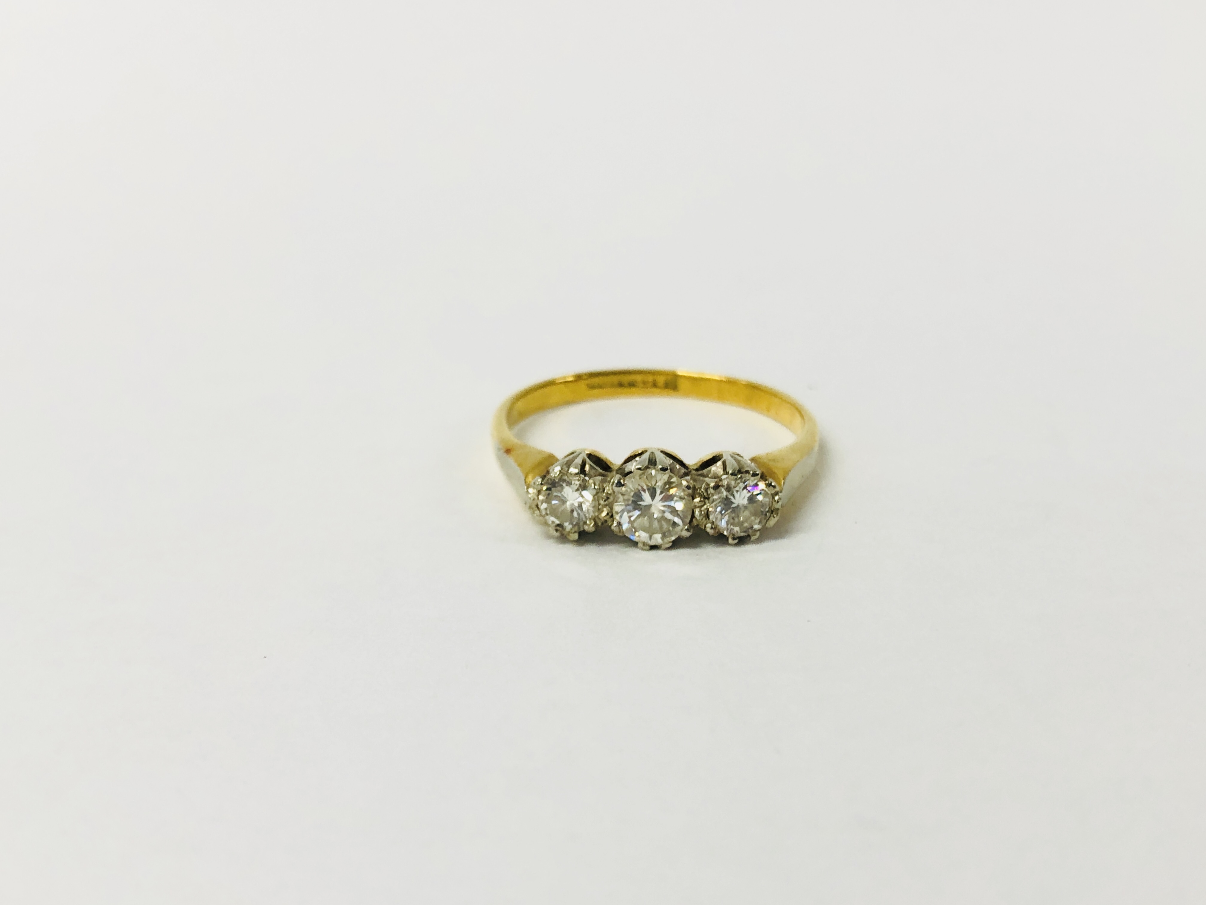 AN 18CT GOLD THREE STONE DIAMOND RING.