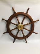 A WOODEN SHIPS WHEEL WITH BRASS BOSS, DIAMETER 66CM.