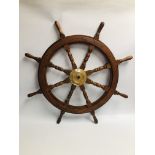 A WOODEN SHIPS WHEEL WITH BRASS BOSS, DIAMETER 66CM.