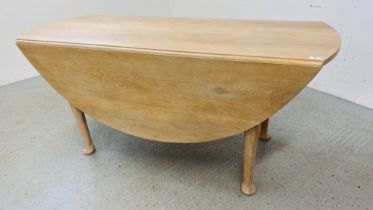 A SOLID LIMED OAK DROP FLAP DINING TABLE WITH OVAL TOP STANDING ON PAD FOOT WIDTH 168CM. X 62CM.