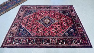 A PERSIAN RUG THE CENTRAL LOZENGE ON A RED STEPPED FIELD - 220CM. X 310 CM.