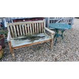 A WOODEN GARDEN BENCH W 121CM AND A DECORATIVE CAST METAL PATIO TABLE DIAMETER 81CM.