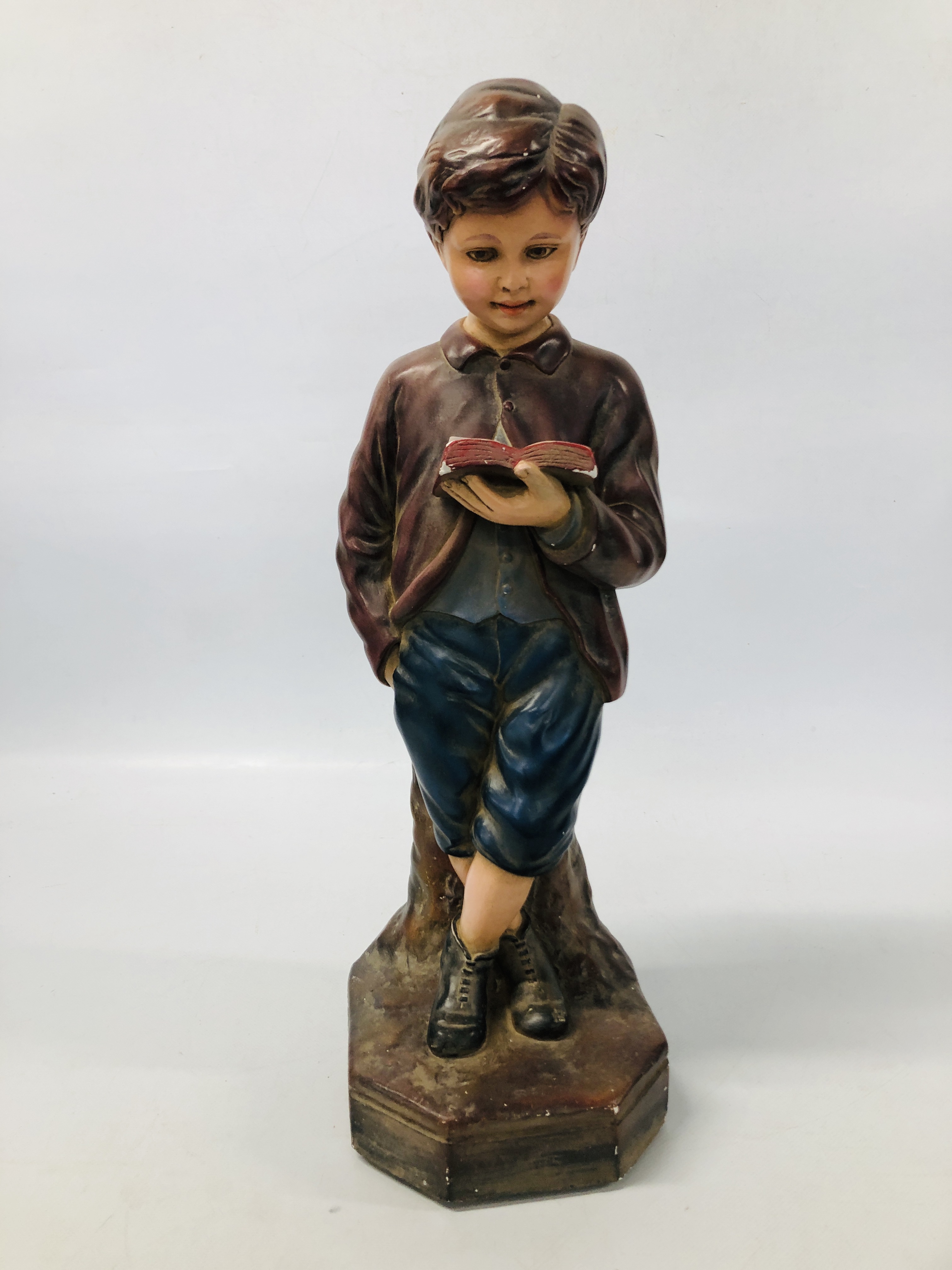 A VINTAGE POLYCHROME PLASTER STUDY OF A YOUNG BOY READING "INTERIORS No 12" HEIGHT 50CM.