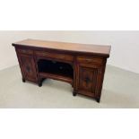 AN EDWARDIAN MAHOGANY TWO DOOR THREE DRAWER SIDE BOARD WITH OPEN CENTRAL SHELF AND CARVED PANEL