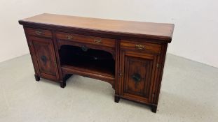 AN EDWARDIAN MAHOGANY TWO DOOR THREE DRAWER SIDE BOARD WITH OPEN CENTRAL SHELF AND CARVED PANEL