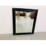 A LARGE BLACK FRAMED WALL MIRROR 112CM X 95CM.