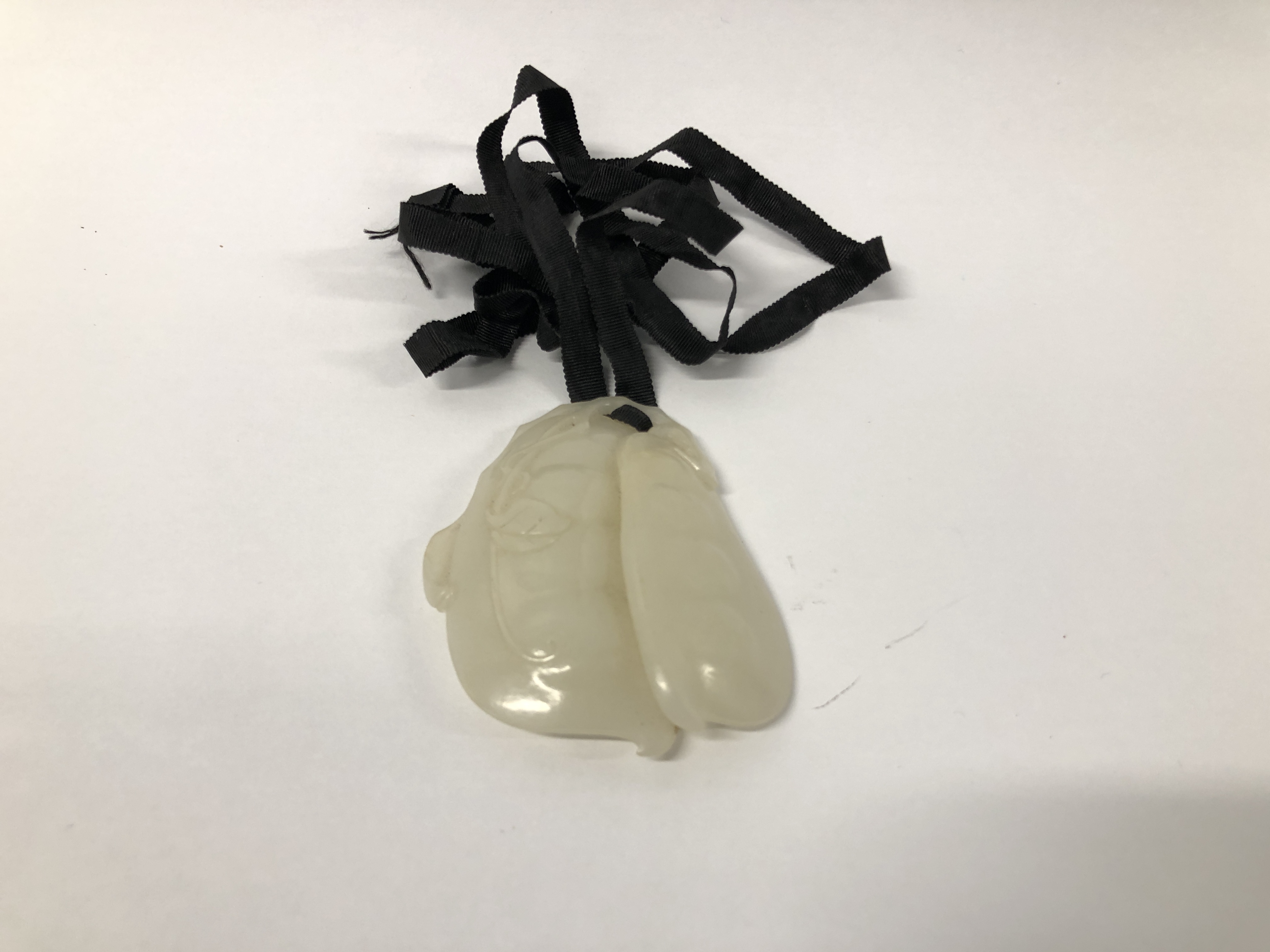 A HAND CARVED JADE PENDANT.